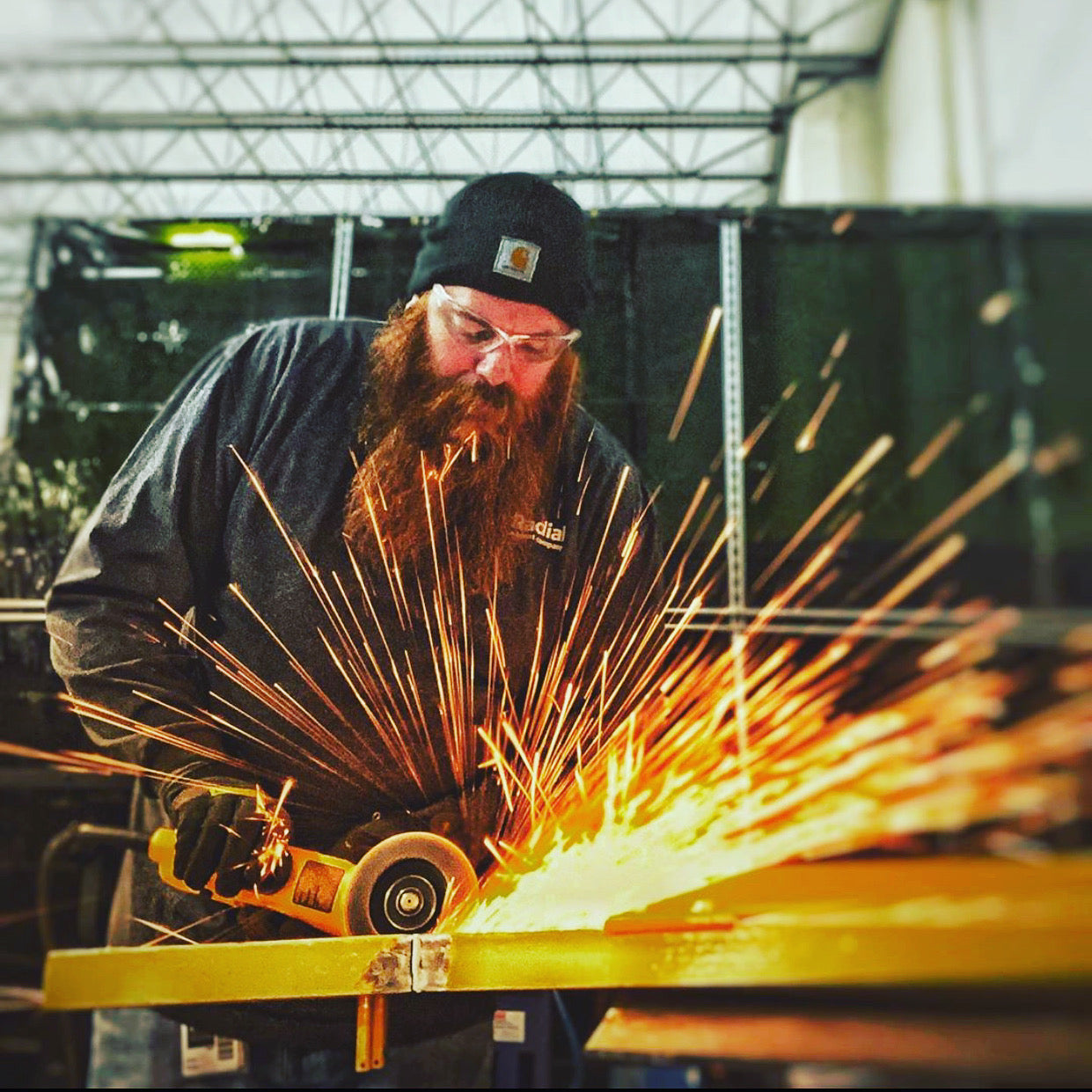Bearded metalworker grinding steel with sparks flying everywhere - Clean Chaos beard wash built for the working man