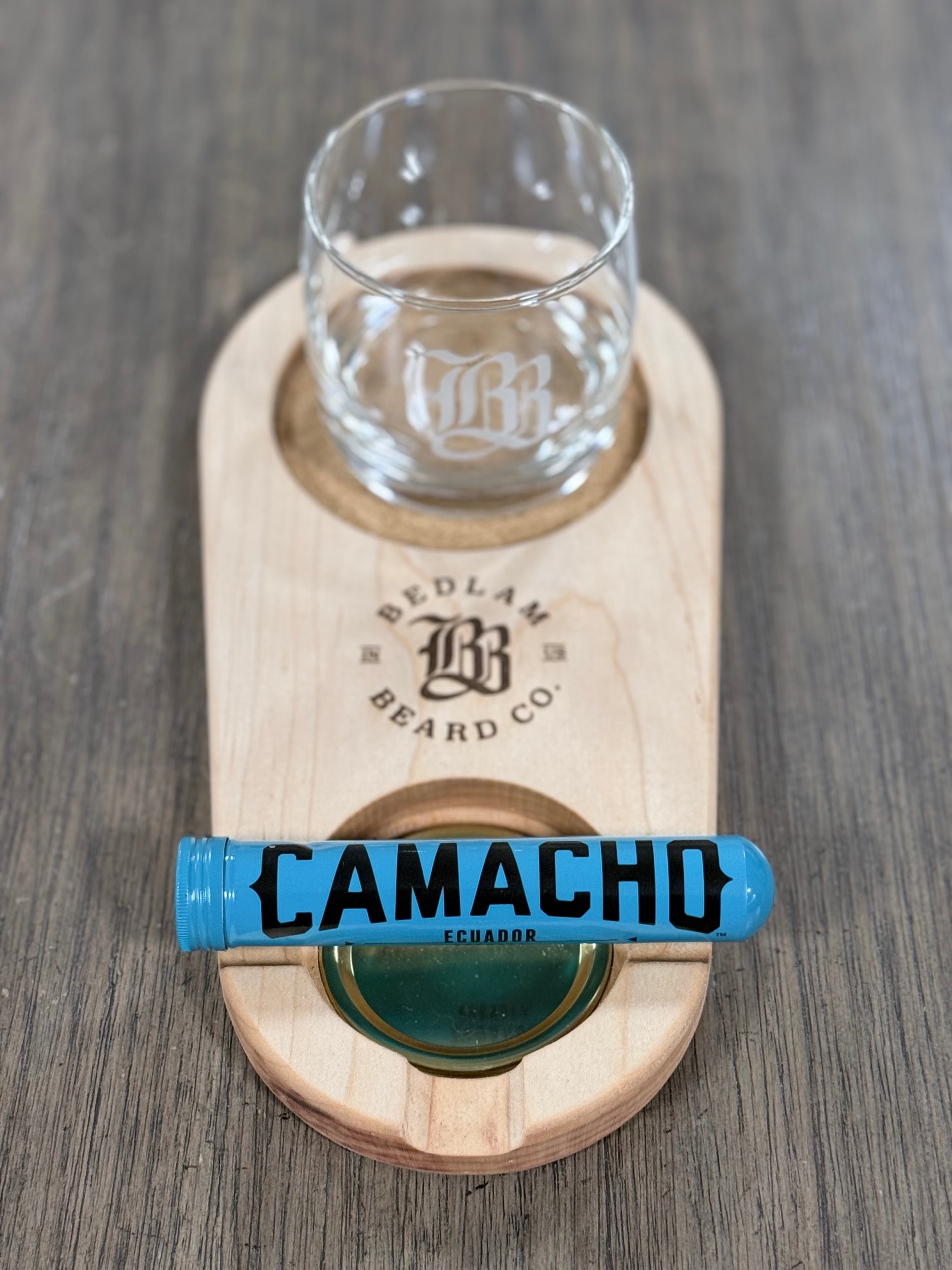 Wooden coaster with glass and bottle holder cork on a wooden surface, cigar holder, featuring Bedlam Beard Co branding.