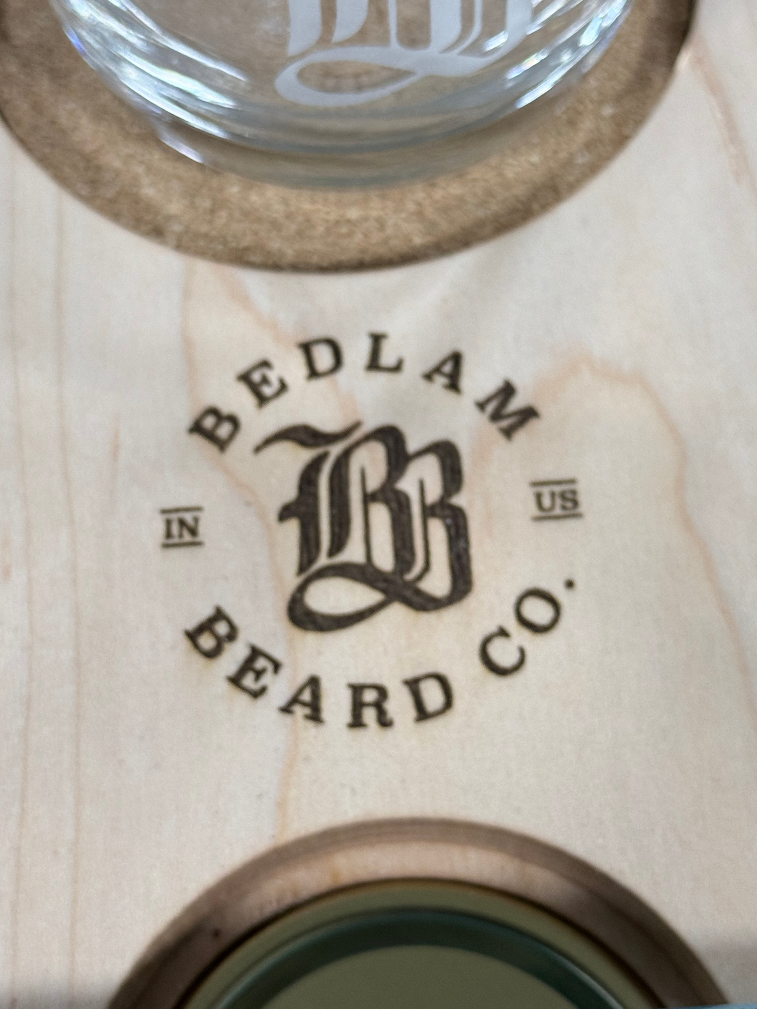 Wooden product with 'Bedlam Beard Co.' branding on a light wood background